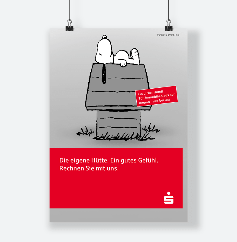 Zu sehen ist ein City Light Plakat zur Snoopy-Kampagne mit dem Key-Visual Snoopy auf der Hundehütte und zwei Botschaften. Erstens: Ein dicker Hund! 300 Immobilien aus der Region nur bei uns. Und zweitens: Die eigene Hütte. Ein gutes Gefühl. Rechnen Sie mit uns.  