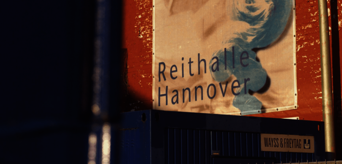 Zu sehen ist ein Detailfoto eines Schildes an der sanierungsbedürftigen alten Reithalle Hannover.