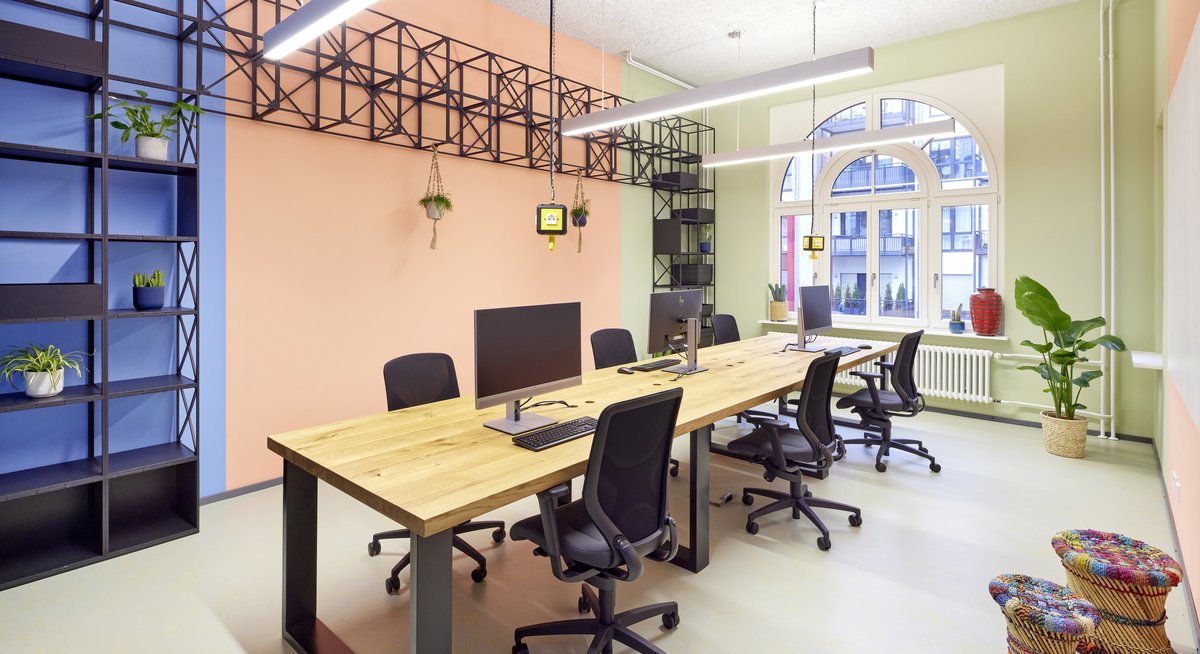 Das Bild zeigt einen modern ausgestatteten und in drei verschiedenen Farben angemalten Büroraum im Co-Creation-Space GundWERK.